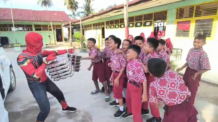 MBG - Petugas Satuan Pelayanan Pemenuhan Gizi (SPPG) di Kabupaten Polewali Mandar (Polman), Sulawesi Barat (Sulbar), berubah jadi superhero saat mengantarkan MBG ke sekolah, Selasa (3/2/2026).