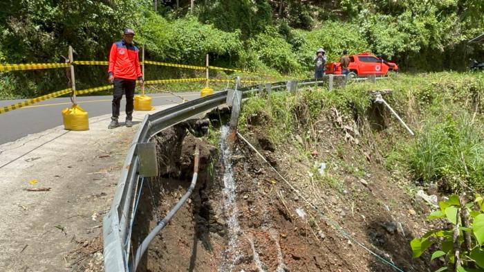 AMBLAS JALAN- Kondisi jalan amblas sepanjang 12 meter di Desa Kelapa Dua, Kecamatan Anreapi, Kabupaten Polewali Mandar, Kamis (26/2/2026). Petugas memasang garis polisi di sisi jalan yang berbatasan jurang sedalam 8 meter untuk mengantisipasi kecelakaan.
