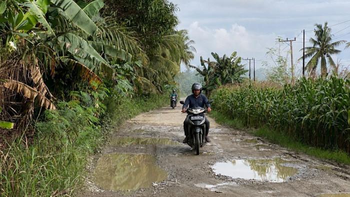 Kondisi jalan utama di Desa Kombiling, Kecamatan Pangale, Kabupaten Mamuju Tengah, Sulawesi Barat, yang rusak parah dan dipenuhi lubang serta genangan air. Warga berharap pemerintah segera melakukan perbaikan permanen karena jalan tersebut menjadi akses vital untuk aktivitas sehari-hari dan distribusi hasil pertanian serta perikanan.