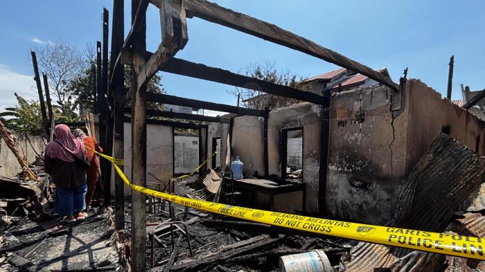 Petugas memasang garis polisi di lokasi kebakaran tiga rumah warga di Kelurahan Polewali, Kabupaten Polewali Mandar, Selasa (10/3/2026).