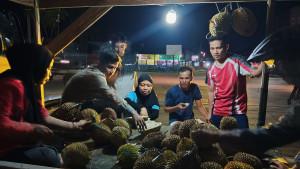Warga-yang-sedang-menikmati-durian-di-Jalan-Arteri-Mamuju-Sulawesi-Barat-Rabu-8102025.jpg