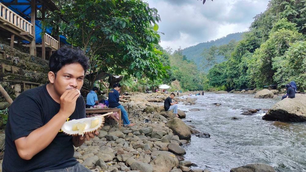 Pengunjung-wisata-Kali-Mamuju-sedang-asyik-menikmati-sensasi-manisnya-durian-lokal.jpg