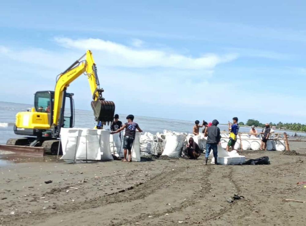 Warga-gotong-royong-mengisi-geobag-di-pesisir-pantai-Mes-Pambutungang.jpg