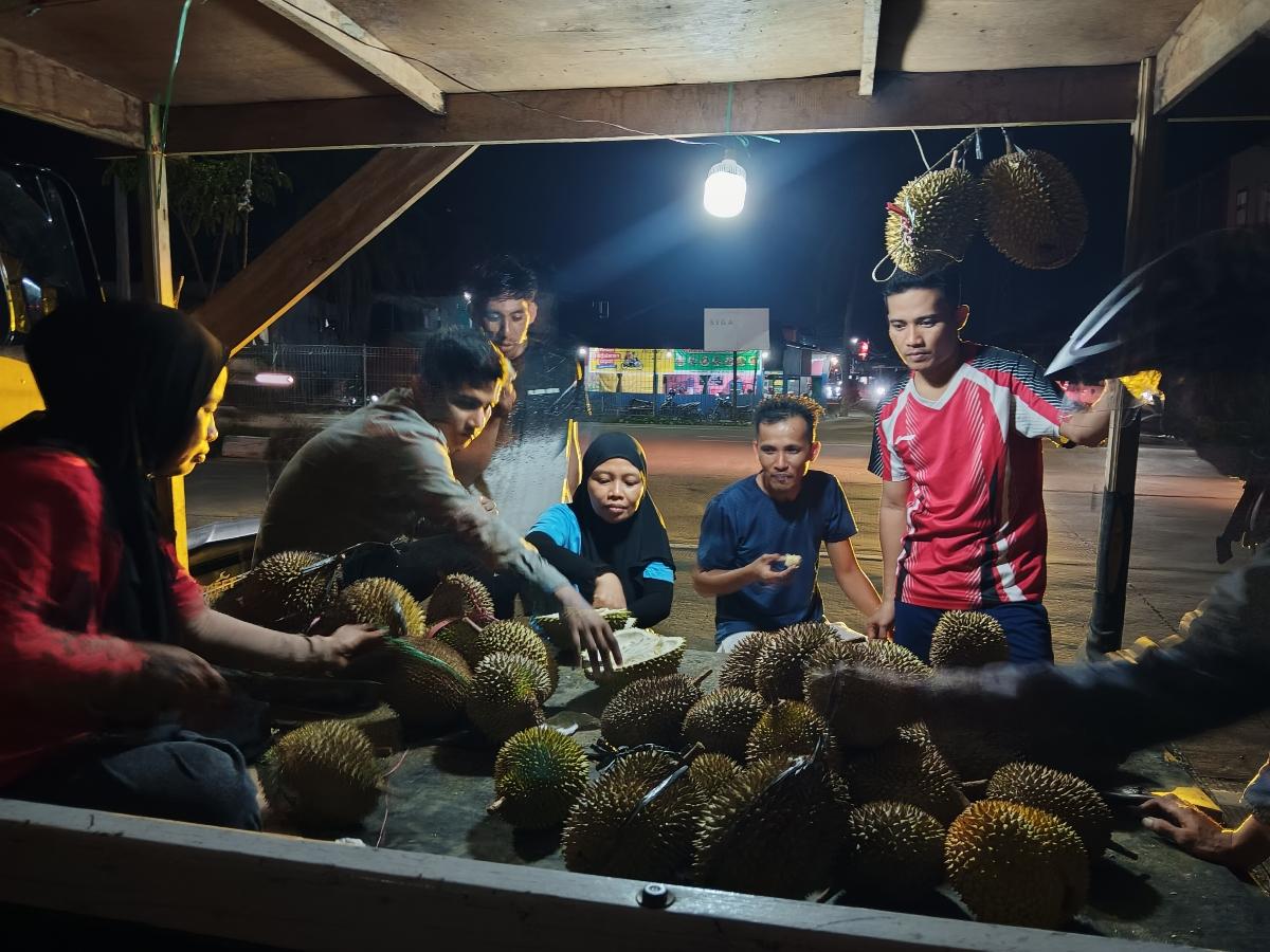 Warga-yang-sedang-menikmati-durian-di-Jalan-Arteri-Mamuju-Sulawesi-Barat-Rabu-8102025.jpg
