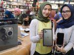 Dua-wanita-memperlihatkan-Hp-iPhone.jpg