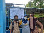 Masni-tegah-bersama-dua-siswa-SMPN-3-Tapalang-Mamuju-saat-ditemui-di-gerbang-sekolah.jpg