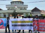 Massa-aksi-aliansi-pemuda-dan-mahasiswa-saat-membentangkan-spanduk-di-depan-kantor-DPRD-Polman.jpg
