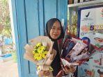 Nuniek-kurniati-30-Guru-Sejarah-SMAN-2-Majene-saat-memegang-bingkisan-dari-siswa.jpg