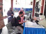Seorang-penumpang-sedang-memperlihatkan-hasil-tes-PCR-nya-kepada-petugas.jpg