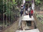 Warga-antri-untuk-melintas-di-atas-jembatan-yang-sudah-rusak-di-Desa-Lenggo.jpg