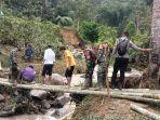 Warga-dan-personel-TNI-Polri-membuat-jembatan-darurat-pasca-luapan-air-terjun.jpg