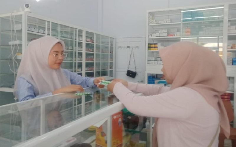 pembeli-tengah-menerima-obat-maag-dari-petugas-Apotek-Barakati.jpg