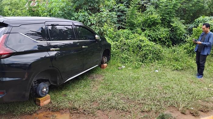 BAN MOBIL DICURI -- Kondisi mobil yang baru saja keempat ban dan velgnya digondol maling di Jalan Sei Betung, Kelurahan Siring Agung, Kecamatan Ilir Barat I, Senin (16/2/2026). Kondisinya diganjal batu bata oleh pelaku.