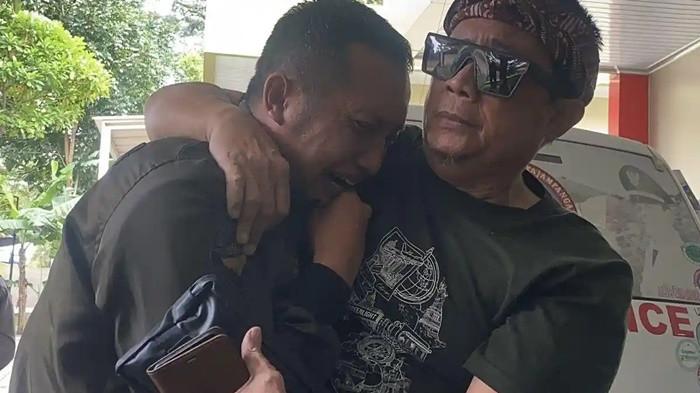 MANANGIS: Anwar Satibi (kiri) Ayah korban dari bocah berinisial NS (12 tahun), menangis pilu di pangkuan ayah angkatnya saat Jenazah sang anak dikeluarkan dari ruang autopsi untuk dibawa ke mobil ambulans. Jumat (20/2/2026) siang