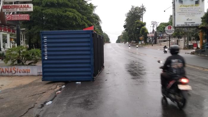 KECELAKAAN - Kontainer yang masih berada di TKP kecelakaan di Jalan Demang Lebar Daun Palembang, Sabtu (14/3/2026). Kecelakaan terjadi saat truk kontainer tabrak halte dan warung makan.