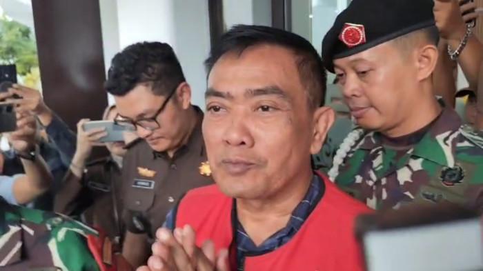 Mantan Wali Kota Cirebon, NA, digiring memasuki ruang konferensi pers dengan mengenakan b