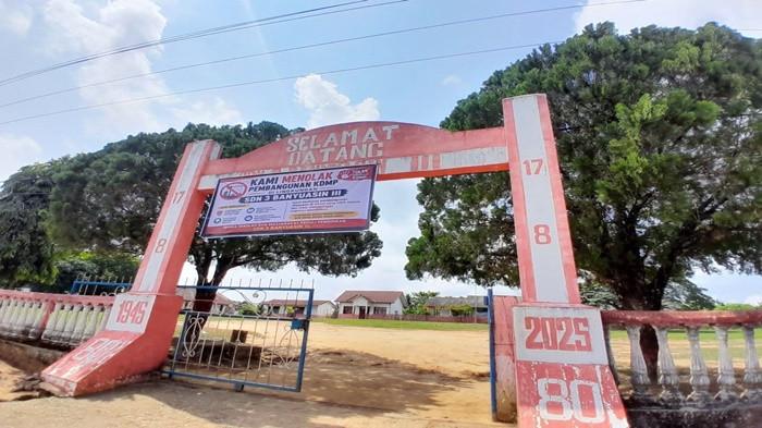 PEMBANGUNAN KDMP DIPROTES -- Spanduk penolakan pembangunan gedung KDMP di halaman sekolah yang dipasang pihak sekolah di depan gerbang SDN 3 Banyuasin III Kabupaten Banyuasin Provinsi Sumsel.
