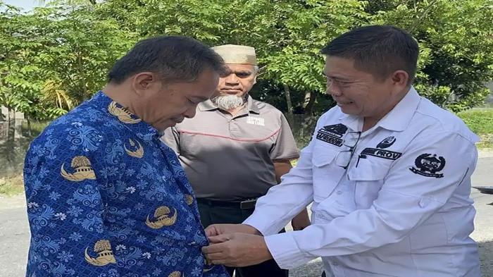 GURU LUTRA - Sosok Safruddin, Kepala SMAN 1 Luwu Utara (kanan) sambut kedatangan Abdul Muis dan Rasnal (kanan) di SMAN 1 Lutra, Rabu (19/11/2025).Safruddin, langsung memakaikan seragam Korpri keduanya.