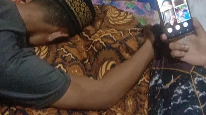 MENANGIS - Ayah Azam menangis memeluk jasad sang anak yang sempat hilang di Muratara, Sumsel.