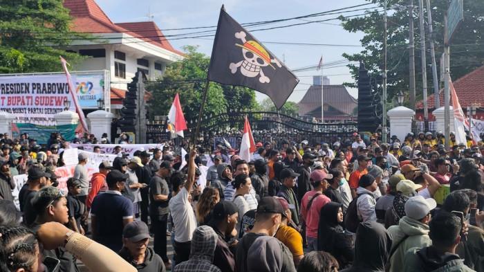 DEMO PATI -  Bendera One Piece berkibar dalam unjuk rasa yang digelar di kawasan Alun-Alun Kabupaten Pati, Rabu (13/8/2025). Massa menuntut Bupati Pati, Sudewo, mundur dari jabatannya.