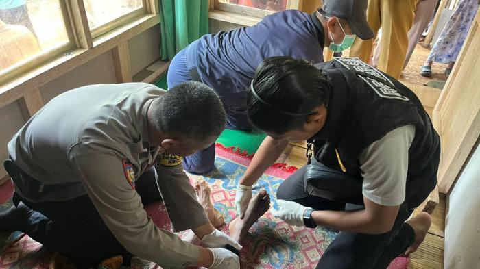 KAKI DIGIGIT ULAR - Petugas sedang memeriksa kaki Ocang yang tewas digigit ular King Kobra di jalan setapak dekat rumahnya di Kampung Cipetir RT 08 RW 04, Desa/Kecamatan Cidadap, Kabupaten Sukabumi, Jawa Barat, Senin 7 Oktober 2025. Ocang tewas usai duel dengan king cobra sepanjang 4 meter.