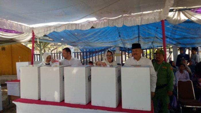 Serba Putih, Alex Noerdin Bersama Keluarga Disambut Warga di TPS 04 Kel Talang Semut