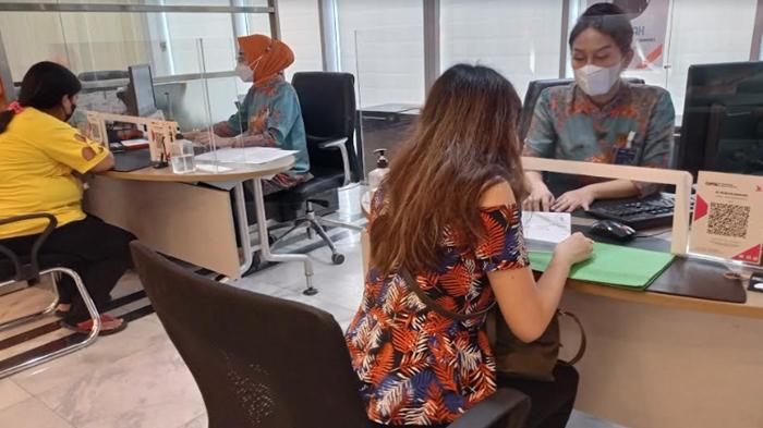 Customer-servis-bank-BNI-tengah-melayani-nasabah-yang-melakukan-transaksi.jpg