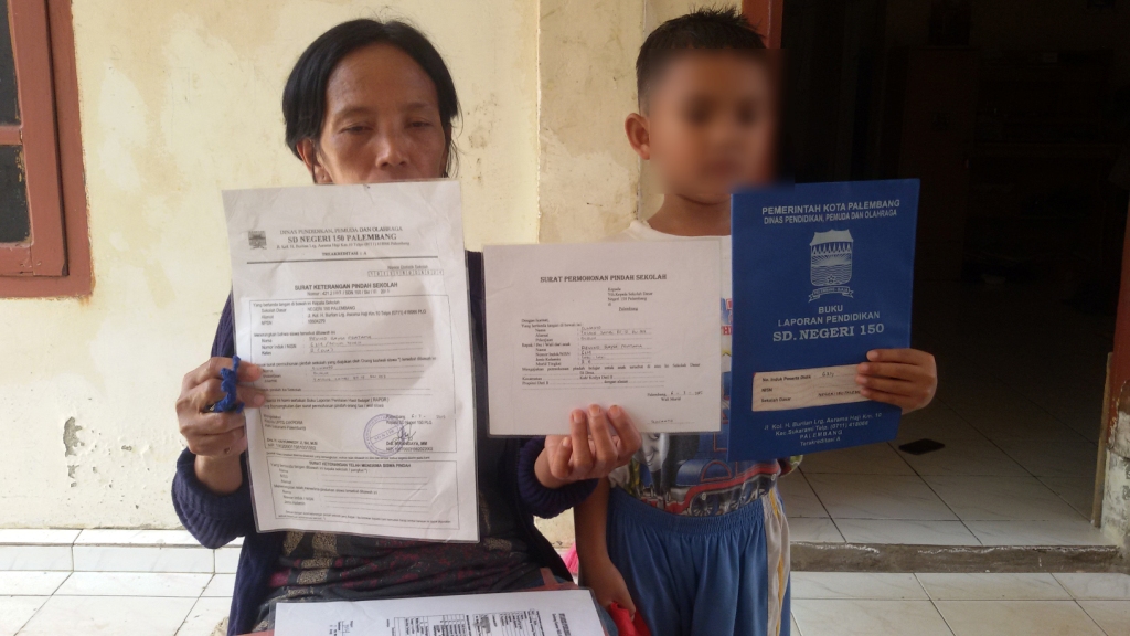 dewi-dan-putranya-ra-menunjukkan-surat-pemberhentian-sdn-150-palembang.jpg