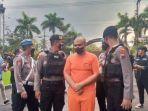 Tersangka-Dhio-digiring-polisi-ke-lokasi-konferensi-pers-di-Ruang-Media.jpg