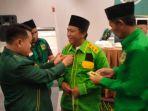 ketua-dpc-ppp-deliserdang-misnan-al-jawi-memakaikan-amriono-baju-hijau-tanda.jpg