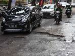pengendara-kendaraan-bermotor-melintasi-jalan-rusak-dan-berlubang-di-jalan-angkatan-45-palembang_20180504_015723.jpg
