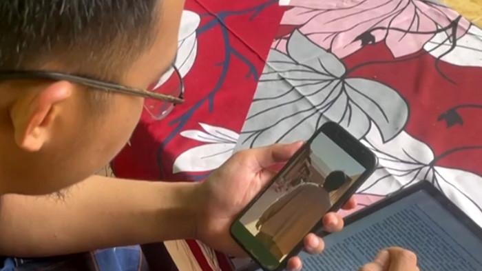 GURU MUDA - Medan Amrullah (30), guru muda sekaligus kreator konten AI saat ditemui di kediamannya di Dusun Ngledok, Desa Mojokrapak, Kecamatan Tembelang, Kabupaten Jombang, Jawa Timur, Senin (17/11/2025). Hobi eksperimen dengan teknologi AI kini jadi penghasilan tambahan lebih.