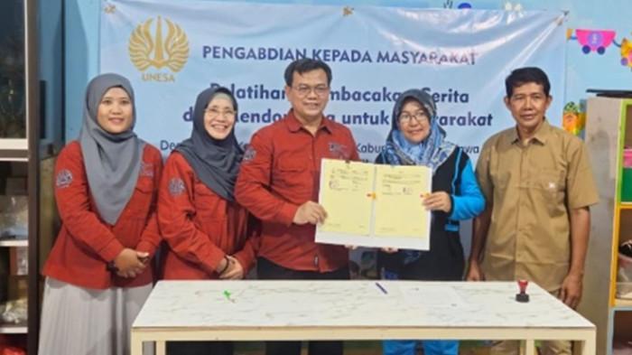 MEMBACA - Tim Pengabdian Kepada Masyarakat (PKM) Pusat Literasi, Lembaga Penelitian dan Pengabdian Masyarakat (LPPM), Universitas Negeri Surabaya (Unesa) menyediakan taman bacaan untuk masyarakat di Desa Doudo, Minggu (6/7/2025).