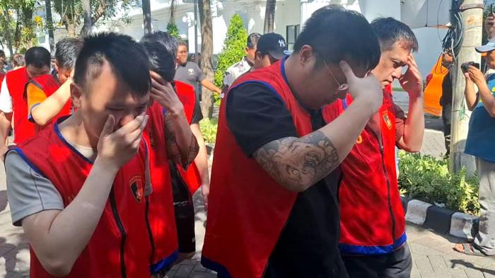 DIAMANKAN - Puluhan warga Negara Jepang, China dan Taiwa, dibawa ke ruang tahanan Mapolrestabes Surabaya, Jumat (8/5/2026). Sebanyak 44 tersangka diamankan polisi lantaran terlibat kasus scamming jaringan internasional dan penyekapan