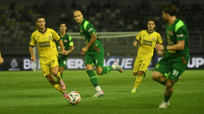 DUEL - Bek tengah Persebaya, Risto Mitrevski (tengah kaus hijau) berduel dengan pemain Semen Padang dalam perebutan bola di Stadion GBT (19/9/2025). Laga tersebut ia mengalami cedera bahu bagian kiri. Akan menjalani pemulihan di Kroasia.