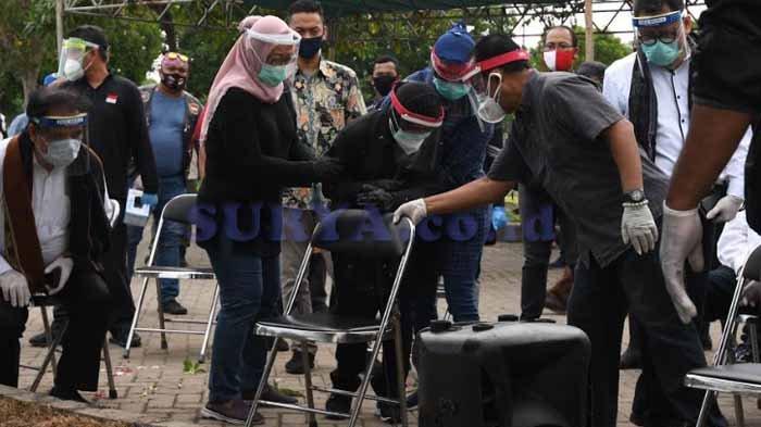 Wali Kota Surabaya Tri Rismaharini dipegangi pejabat Pemkot saat mengikuti prosesi pemakaman Kepala DP5A Chandra di TPU Keputih, Rabu (15/7/2020). (SURYA.co.id/Ahmad Zaimul Haq)