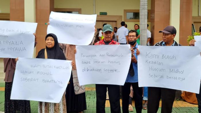 DEMO - Warga Desa Imaan saat demo di kantor Pengadilan Negeri Gresik, Jawa Timur pada Senin (26/1/2026). Warga menuntut AM, terdakwa kasus pembunuhan agen BRILink, Wardatun Toyyibah, dihukum mati.