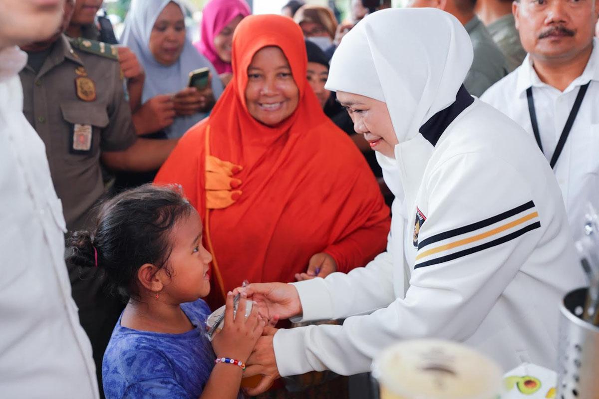 Gubernur-Jawa-Timur-Khofifah-Indar-Parawansa-membagikan-telur-ayam-pada-anak-anak.jpg