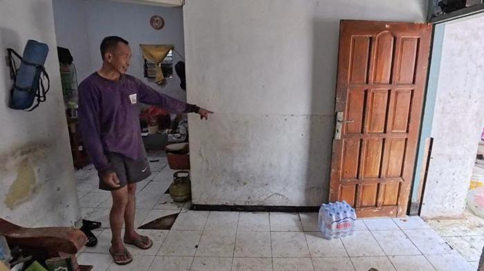 KORBAN-BANJIR-Suwarto-menunjukan-bekas-ketinggian.jpg