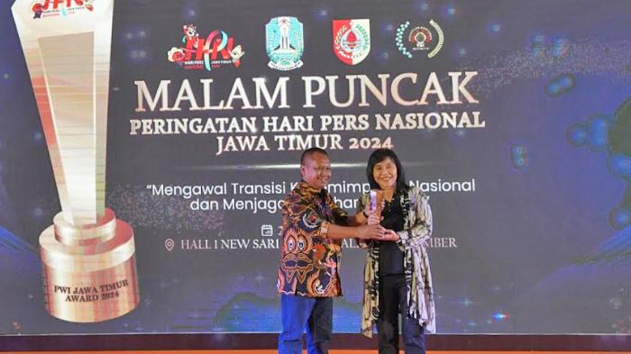 Ketua-PWI-Jatim-Lutfil-Hakim-saat-menyerahkan-penghargaan-kepada-Bank-Jatim.jpg