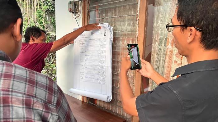 Komisioner-KPU-Jember-Ahmad-Hanafi-mencocokan-Hasil-C-Plano-Pemilu-2024.jpg