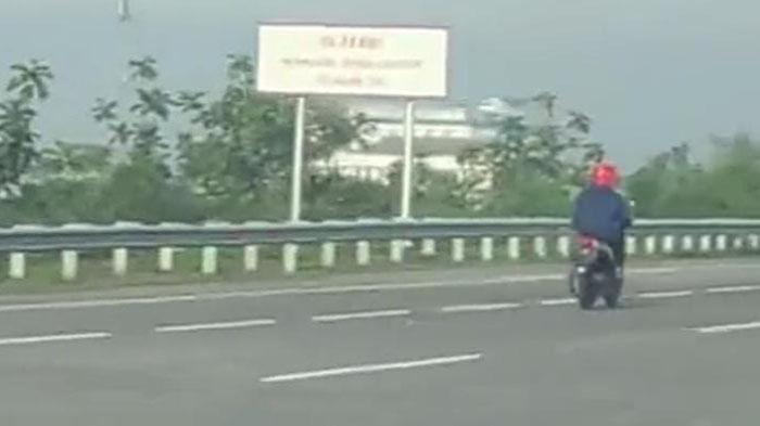 Tangkapan-layar-video-pemotor-matik-berhelm-merah-Tol-Waru-Gunung-Jatim.jpg