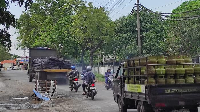 Lubang Besar Mengintai Pengendara di Jalan Mayjend Sungkono Gresik, Warga Tutupi Dengan Kayu Palet