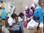 anak-Sasmiati-saat-menerima-bantuan.jpg
