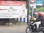 pengendara-motor-melintas-di-depan-spanduk-imbauan.jpg