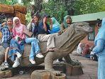 pengunjung-foto-bersama-di-atas-patung-komodo-di-Kebun-Binatang-Surabaya.jpg