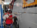 seorang-kondektur-menyemprotkan-disinfektan-di-badan-bus.jpg