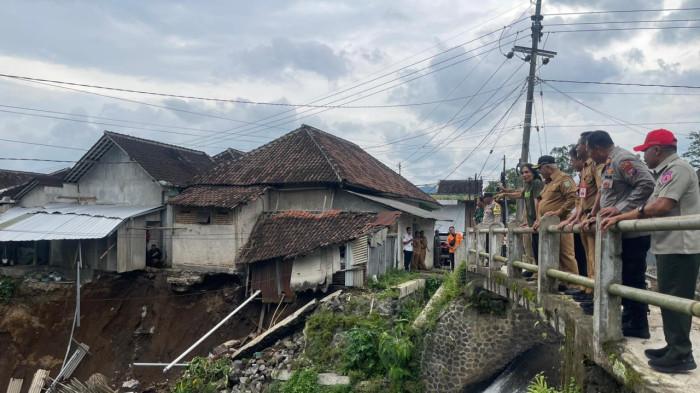 CEK LOKASI - Bupati Sanusi mengecek tembok tebing penahan Sungai Sumber Gong yang ambrol karena diterjang hujan, Senin (8/12/2025).