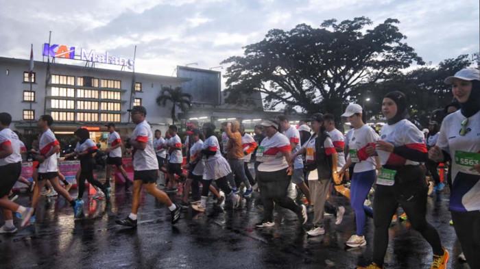 IKON KOTA MALANG - Pelari Emba Jetbus Run 2026 di Kota Malang, Jawa Timur saat melintasi salah satu ikon kota Malang, stasiun Malang, Minggu (18/1/2026). Sebanyak 3600 pelari mengikuti gelaran tersebut dengan kategori 5K (Kilometer) dan 10K