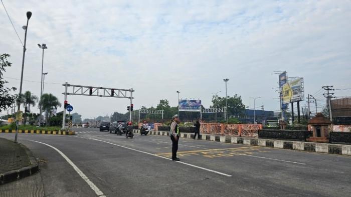 PENGAMANAN - Anggota Satlantas Polres Malang melakukan pengaturan arus lalu lintas di simpang empat Karanglo, Minggu (21/12/2025). Arus lalu lintas di wilayah Malang mulai meningkat pada akhir pekan menjelang libur Natal dan Tahun Baru 2026 (Nataru).